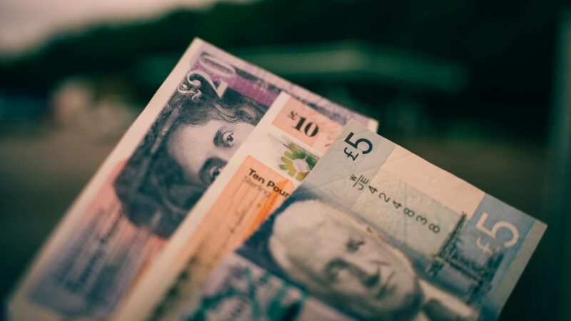 British five and ten pound notes close-up with blurred background.